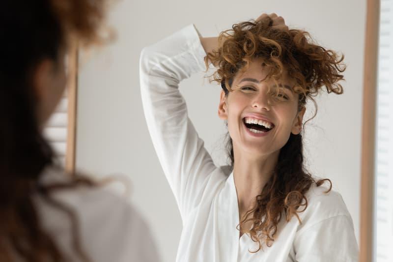 Woman holding her hair up with her hand and laughing